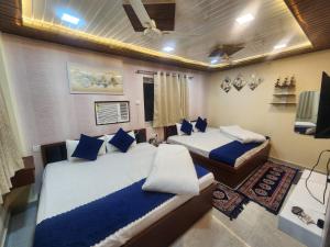two beds in a room with blue pillows at The Trishul Stay in Varanasi