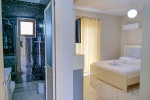 a bedroom with a bed and a glass shower at Vila Balani in Ksamil +143 photos