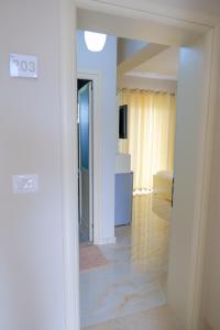 a white room with a bed and a mirror at Vila Balani in Ksamil