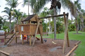 a playground with a tree house in a park at Leisure Tourist Park in Port Macquarie