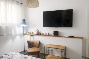 a room with a tv on a wall with a chair and a table at INDUSTRIAL CHIC HOUSE - Private parking in Orvieto