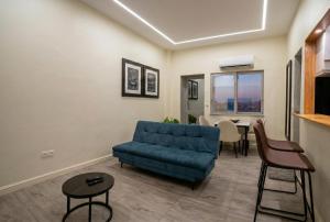 a living room with a blue couch and a table at Mutamba Prime Stay in Luanda