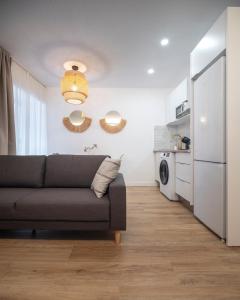 a living room with a couch and a kitchen at Apartamento Donoso Cortés in Badajoz
