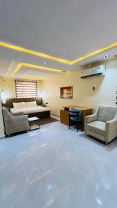 a large living room with a bed and two chairs at Feliza Hotel and Suites in Abeokuta
