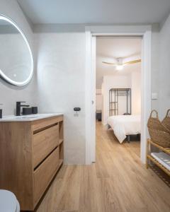 a bathroom with a sink and a bedroom with a bed at Apartamento Donoso Cortés in Badajoz