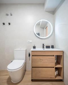 a bathroom with a toilet and a mirror at Apartamento Donoso Cortés in Badajoz