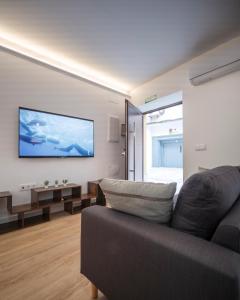a living room with a couch and a flat screen tv at Apartamento Donoso Cortés in Badajoz