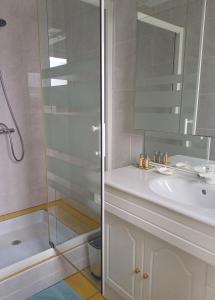 a bathroom with a white sink and a shower at Un B&B à Loktudi in Loctudy