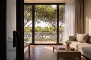 a living room with a couch and a large window at MarePineta Resort in Milano Marittima