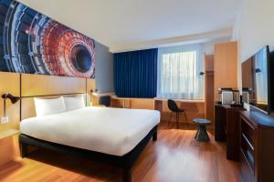 a hotel room with a bed and a television at ibis Genève Petit Lancy in Geneva +81 photos