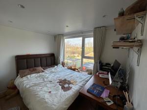 a bedroom with a bed and a desk and a window at Baoyan Kingston - Guest House with 2 bedrooms with 1 toilet-washing room in Kingston upon Thames