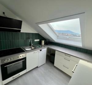 eine Küche mit Fenster, Spüle und Herd in der Unterkunft Schlierbachblick in Eschwege