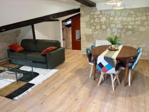 a living room with a table and a couch at gite 3 le havre in Aubeterre-sur-Dronne +13 photos