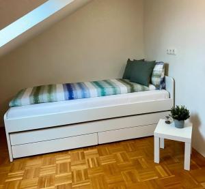 ein weißes Bett in einem Zimmer mit einem Tisch in der Unterkunft Schlierbachblick in Eschwege + 1 Foto