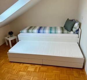 ein weißes Bett in einem Zimmer mit Treppe in der Unterkunft Schlierbachblick in Eschwege