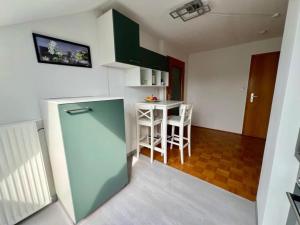 eine Küche mit Kühlschrank und einem Tisch mit Stühlen in der Unterkunft Schlierbachblick in Eschwege