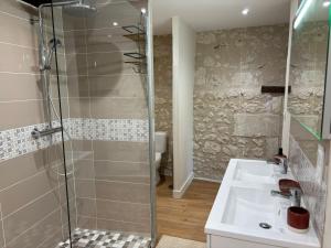 a bathroom with a glass shower and a sink at gite 3 le havre in Aubeterre-sur-Dronne