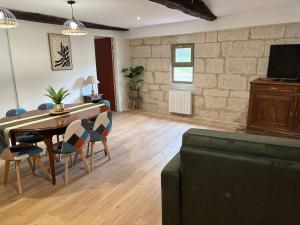 a living room with a table and chairs and a tv at gite 3 le havre in Aubeterre-sur-Dronne