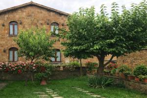 a brick house with a tree in front of it at INDUSTRIAL CHIC HOUSE - Private parking in Orvieto