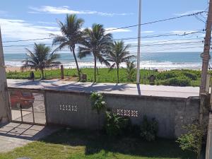 a view of a beach with palm trees and the ocean at LAR DE PRAIA - Suíte in Serra