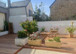 a patio with three potted plants and a table on a deck at Un B&B à Loktudi in Loctudy