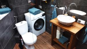a bathroom with a washing machine and a washer and dryer at Through the Art Gallery in Piła +11 photos