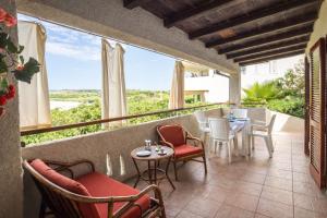 a balcony with chairs and tables and a view at Terrazza sul Mare Case Vacanze in Capo Rizzuto