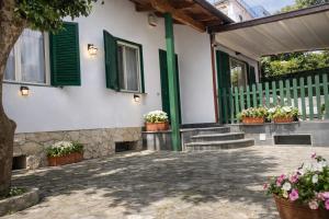 a house with green shutters and potted plants at Enjoy Home Sorrento in Sorrento