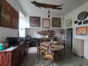 a kitchen with a table and chairs in a room at L'Art de l'Être in Saint-Vincent-de-Reins