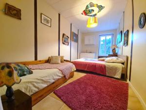 a bedroom with two beds and a red rug at L'Art de l'Être in Saint-Vincent-de-Reins