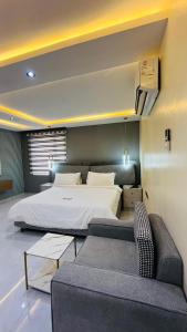 a bedroom with a large bed and a couch at Feliza Hotel and Suites in Abeokuta