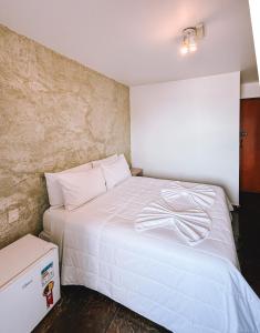 a bedroom with a white bed and a box at Acuario Pousada in Arraial do Cabo