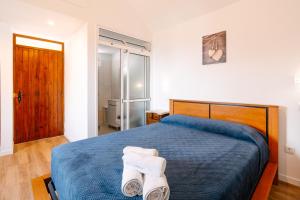 a bedroom with a bed with towels on it at Casa do Faial in Santana