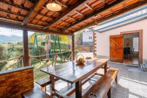 an outdoor dining area with a wooden table and benches at Casa do Faial in Santana