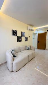 a couch in a living room with pictures on the wall at Feliza Hotel and Suites in Abeokuta +25 photos