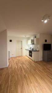 an empty room with a kitchen and a hard wood floor at Cozy Studio Residenz Platz 1 near Neues Schloss Bayreuth in Bayreuth