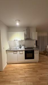a kitchen with white cabinets and a stove top oven at Cozy Studio Residenz Platz 1 near Neues Schloss Bayreuth in Bayreuth