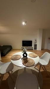 a living room with a white table and chairs at Cozy Studio Residenz Platz 1 near Neues Schloss Bayreuth in Bayreuth