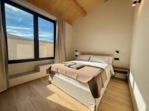 a bedroom with a bed and a large window at Salon Suites in Tremp