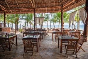 a restaurant on the beach with tables and chairs at VOI Kiwengwa Resort in Kiwengwa