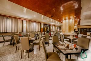 a restaurant with tables and chairs and a bar at Hotiday Venezia Marco Polo in Campalto