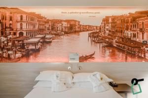 a bed with a picture of a canal at Hotiday Venezia Marco Polo in Campalto
