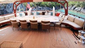 a dining table and chairs on a boat at gold in Fethiye