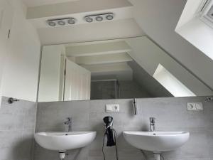 a bathroom with two sinks and a large mirror at Seaside-Amrum-17 in Norddorf +2 photos