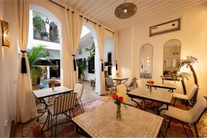 a living room with tables and chairs and a room at Riad Dar Beldia and Spa in Marrakesh