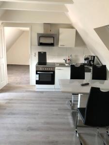 a kitchen with a stove and a table with chairs at Seaside-Amrum-17 in Norddorf