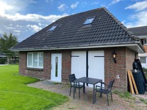 a house with a table and chairs in front of it at Seaside-Amrum-18 in Norddorf