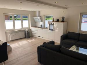 a living room with a couch and a kitchen at Seaside-Amrum-18 in Norddorf