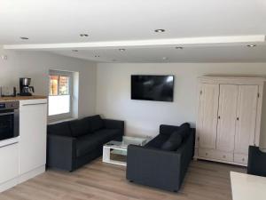 a living room with two couches and a tv at Seaside-Amrum-18 in Norddorf +2 photos