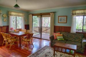 sala de estar con mesa y sofá en Balinga Cottages, en Balingup